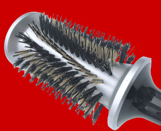 Image of the hairbrush with natural boar bristles and a V shaped double pinned nylon. In a  soft curved row. Also showing the CAPTIVE ENDS™ which control the air and heat.